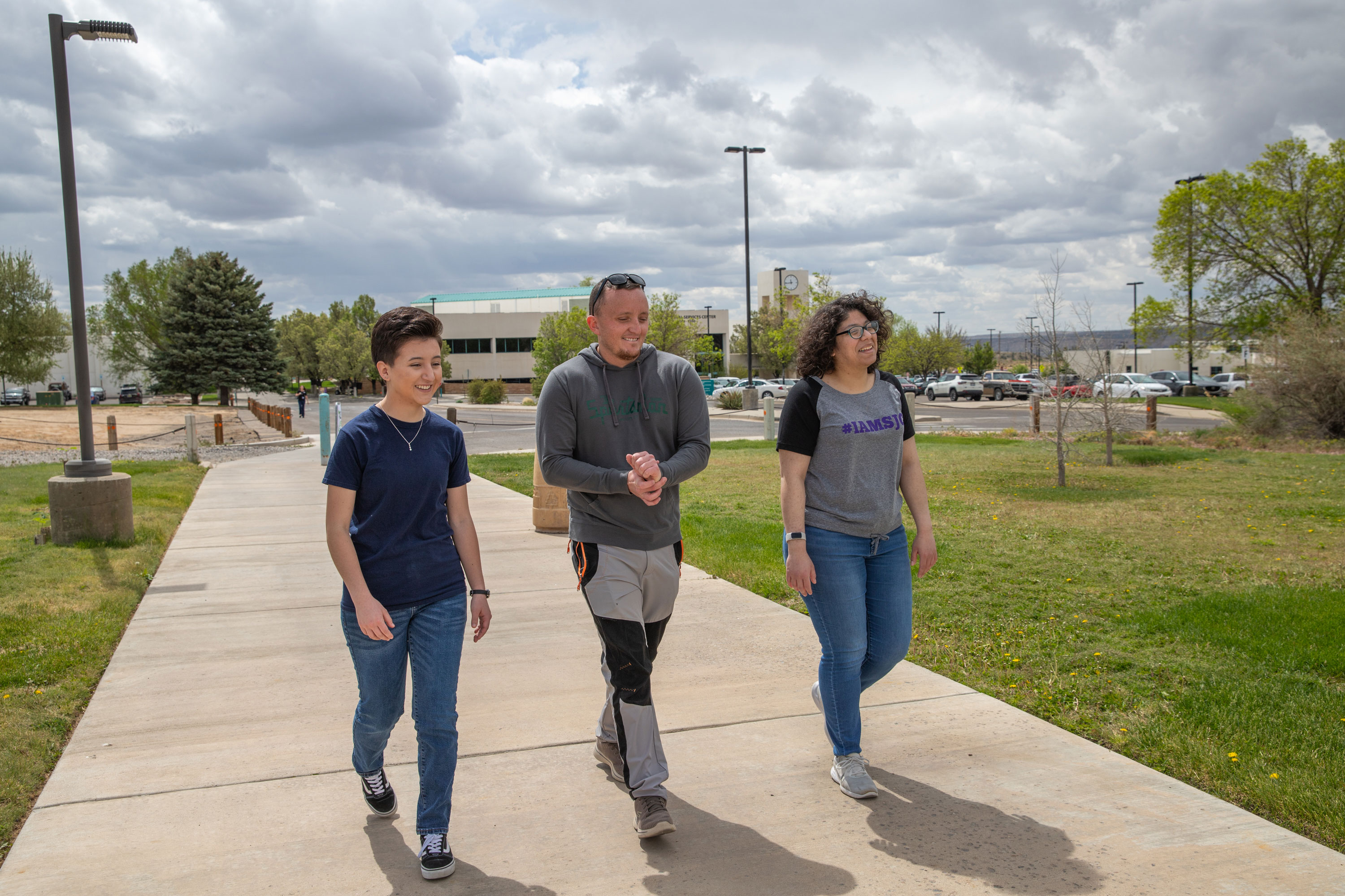 Three students smiling walking across the SJC Campus