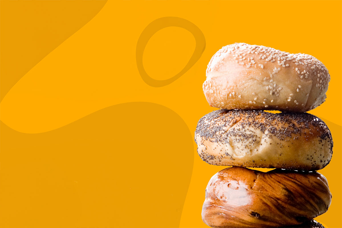 Yellow background with three Bagels to the right; sesame, poppy seed and a swirl.