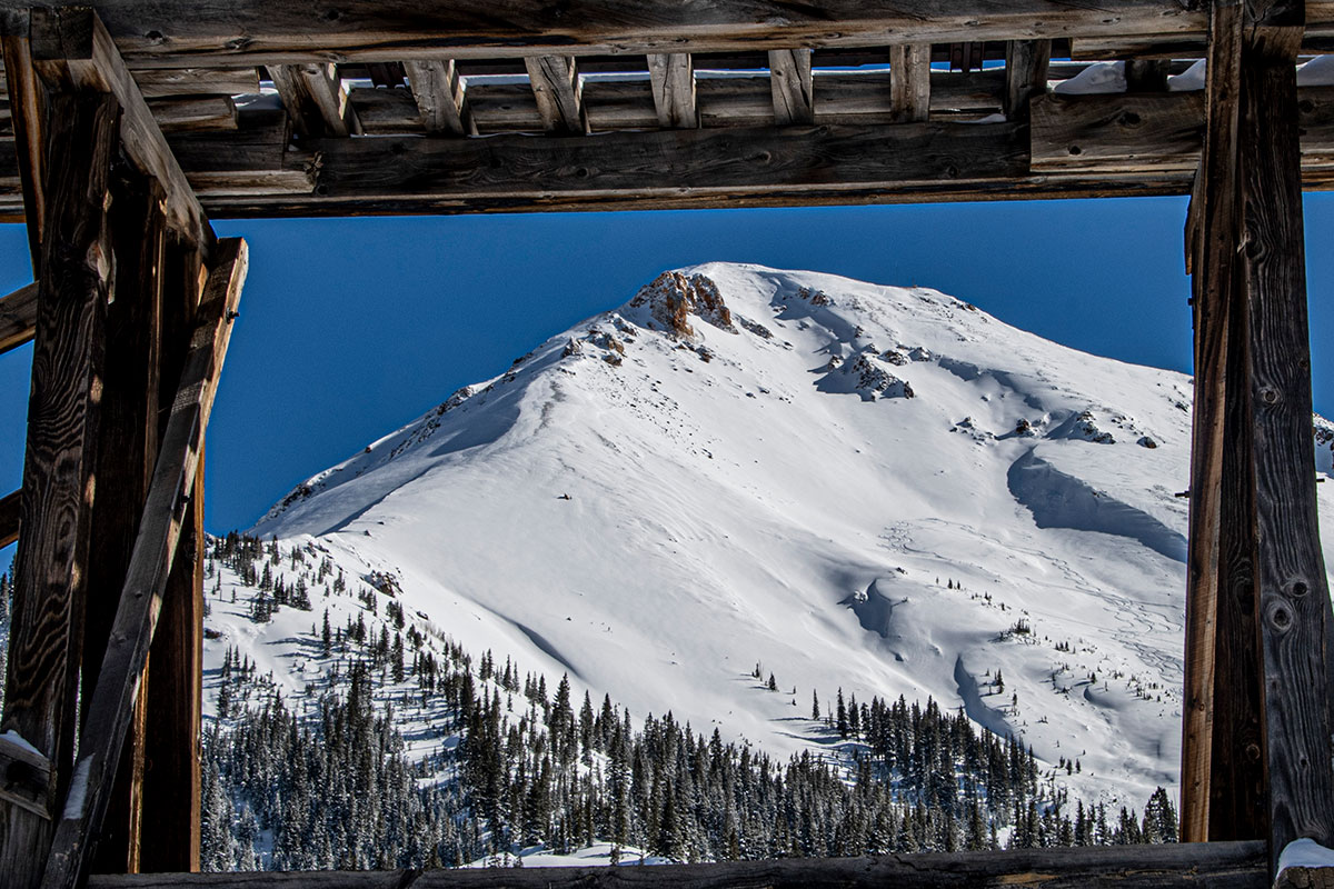 Four Corners Photographic Society photo of a snowy mountain top, trees at the bottom of the hillside looking through a pergola