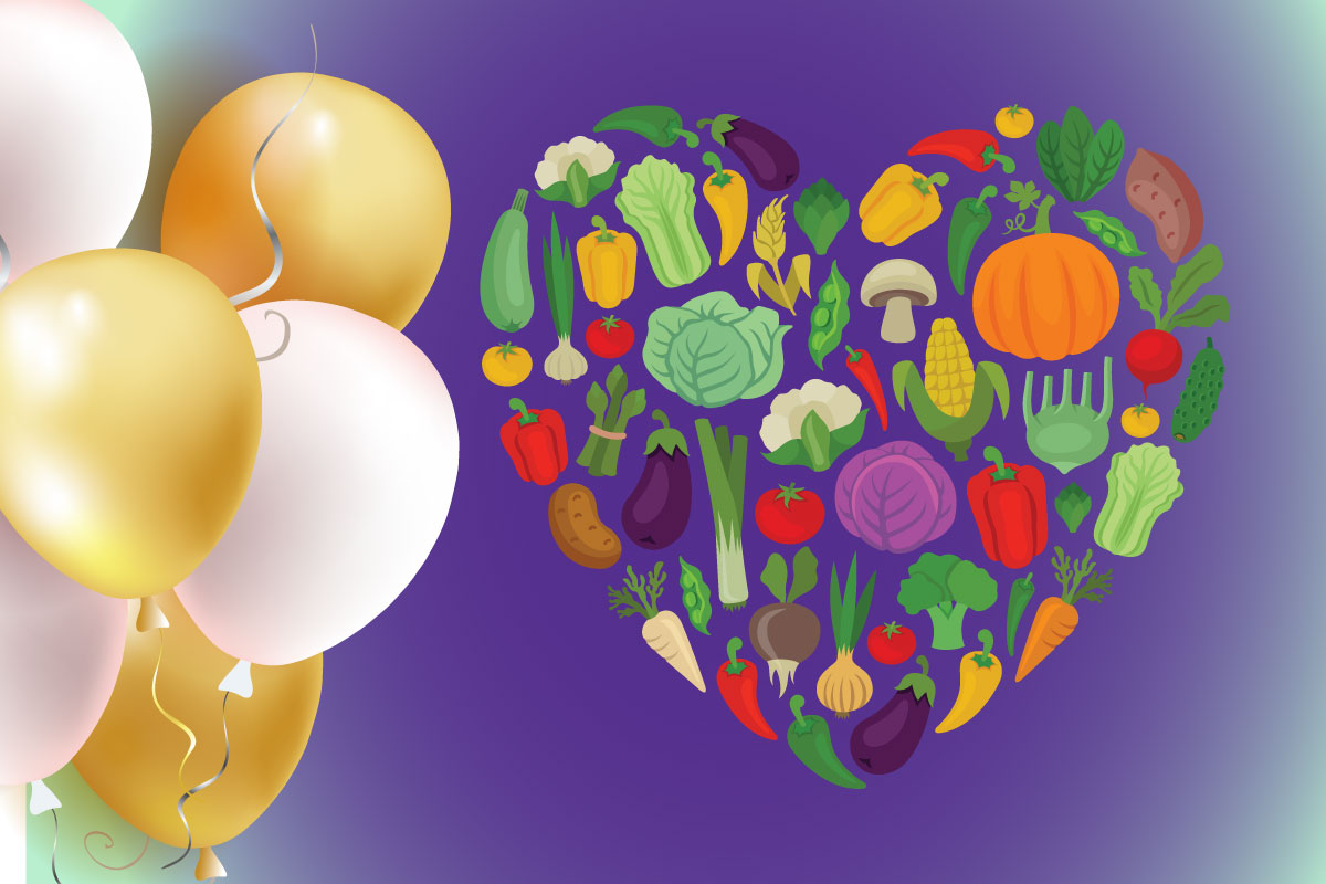 Gold and white balloons to the left with an assortment of vegetables in a heart shape to the right on a purple background.