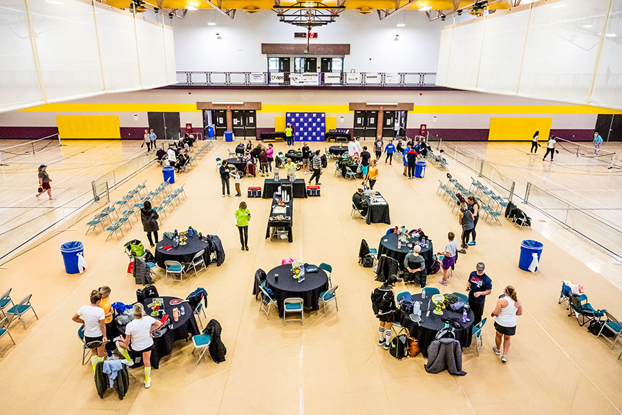 Teams of players at various tables in the SJC HHPC gymnasium participating in the 2025 Pickleball Tournament