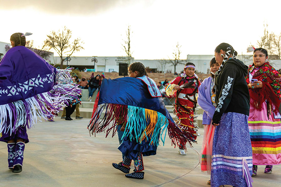 Group of women in their traditional Native American clothing performing a dance at the SJC Campus