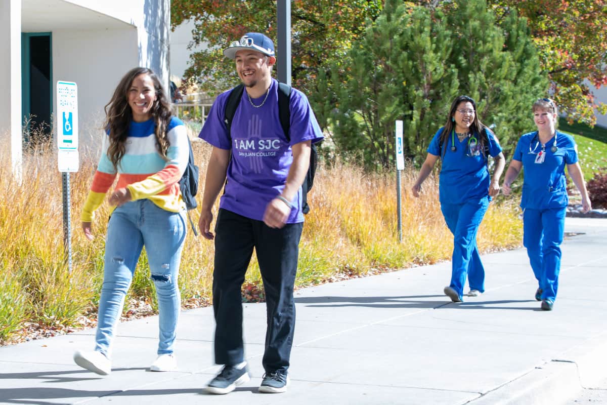 Happy students walking up sidewalk