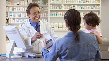 Pharmacist handing customer a prescription