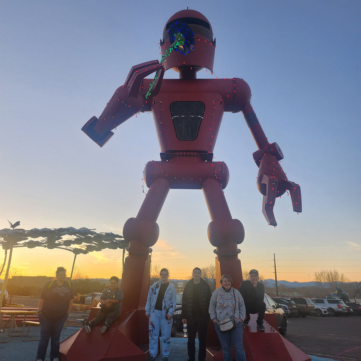 TRIO Students at Meow Wolf in front of a large red robot statue