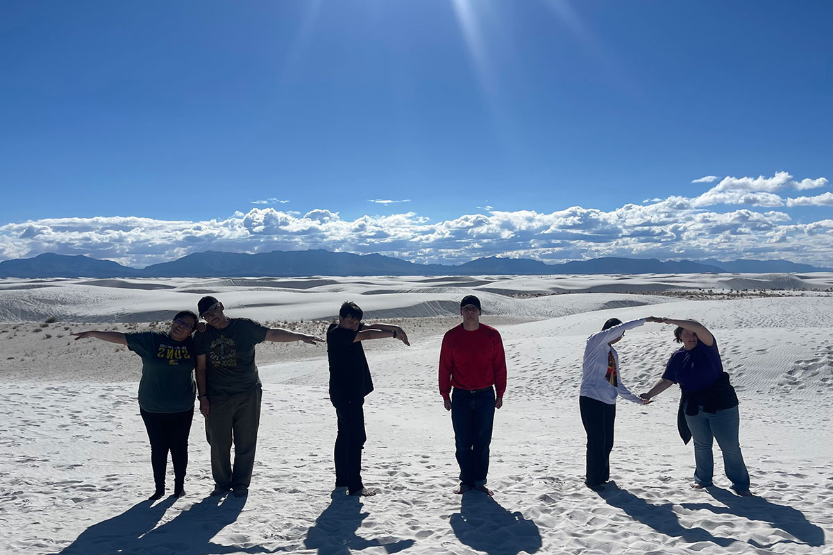SJC Students at White Sands posing in the letters T R I O